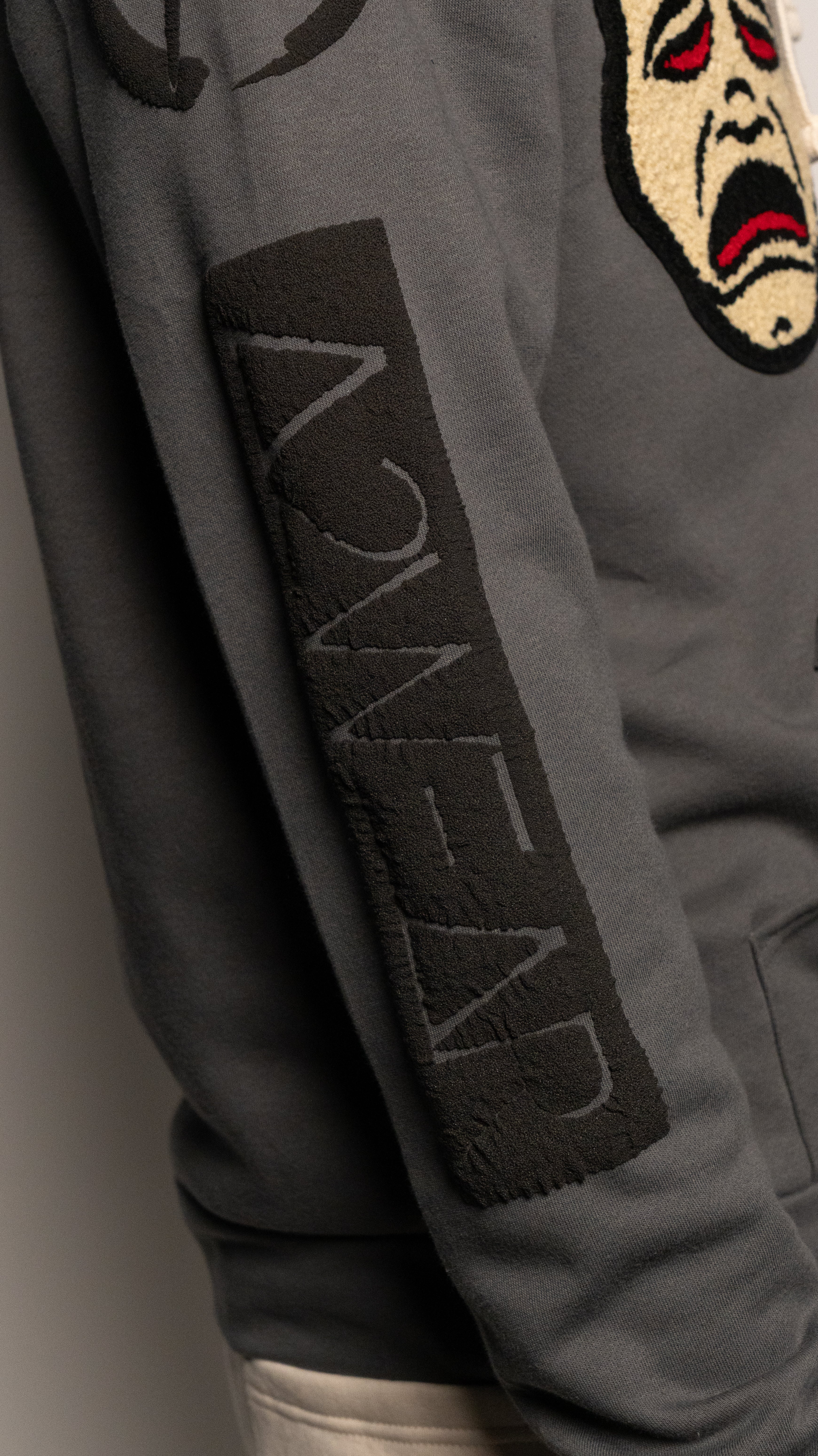 Gray jacket with Art to Wear logo patch on the sleeve against a neutral background
