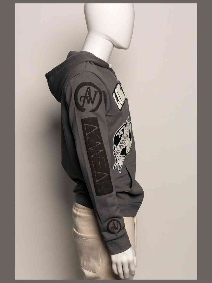 Gray hoodie with patches on a mannequin against a plain background
